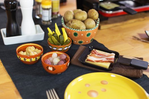 Swiss raclette, traditional specialty of grilled yellow cheese, potatoes and pickles.