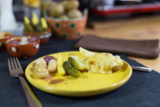 Raclette, traditional specialty of grilled yellow cheese, potatoes and pickles.