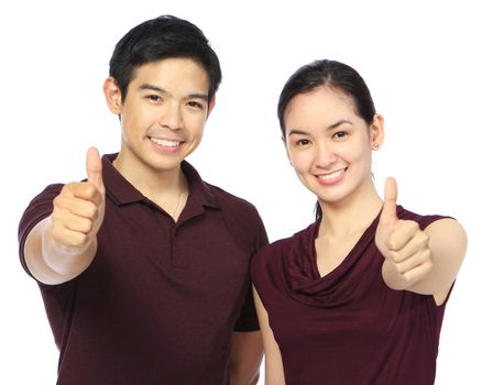A couple in casual clothes doing the thumbs up hand sign