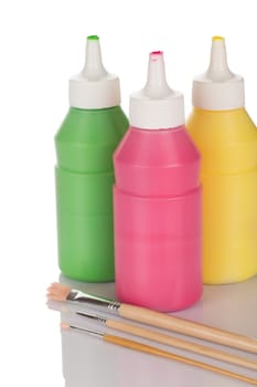 Bottles of paint and pencils isolated on white background close up.