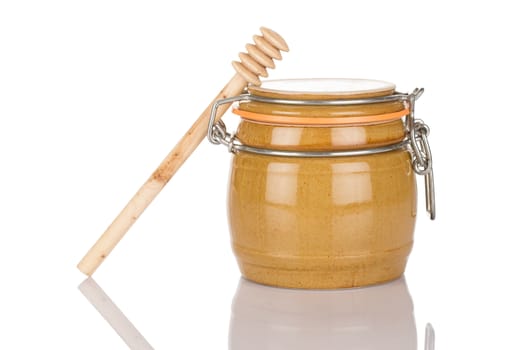 Honey pot and stick isolated on white background close up.