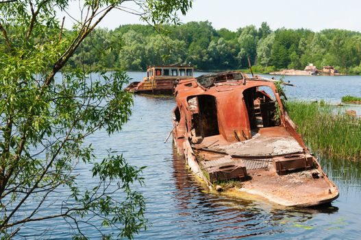 Wrecked abandoned ships on a river after nuclear disaster in Chernobyl, Ukraine