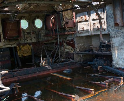 Wrecked abandoned ship interior on a river after nuclear disaster in Chernobyl, Ukraine