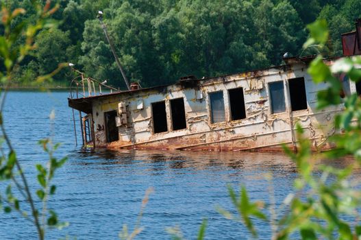 Wrecked abandoned ship on a river after nuclear disaster in Chernobyl, Ukraine