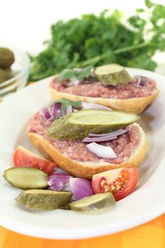 white bread with pickles, onions and parsley on a light background