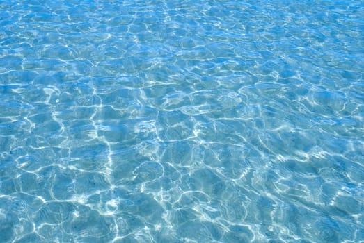 Blue sea water with sunlight reflections.