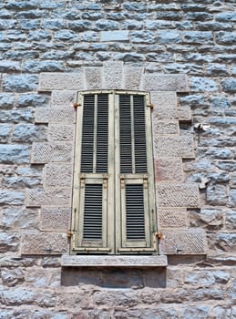 Typical old Mediterranean window with closed shutters