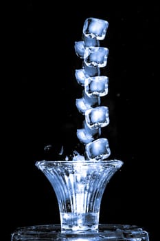 Stroboscopic effect created using flash capturing the motion ice as it splashes into a glass