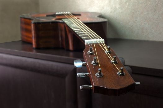 brown six-string acoustic guitar lying on the table