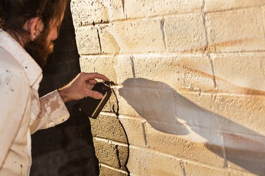 Caucasian graffit artist working on mural with spray paint