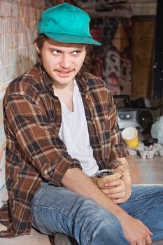 Strange looking teenage male holding beer in brown bag