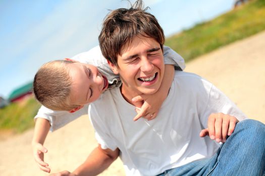 happy teenager and kid on the beach