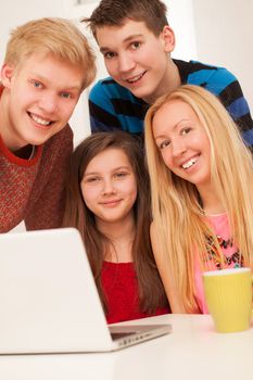 Brothers and sisters having fun at home with notebook