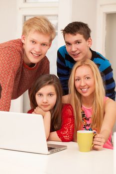 Brothers and sisters having fun at home with notebook