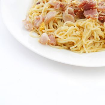 Spaghetti carbonara with fried bacon on white background