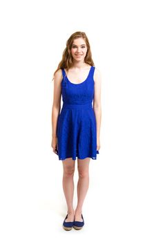 An attractive teen poses for a photo indoors in a lighting studio against a white background with a fashion style feel to the image.