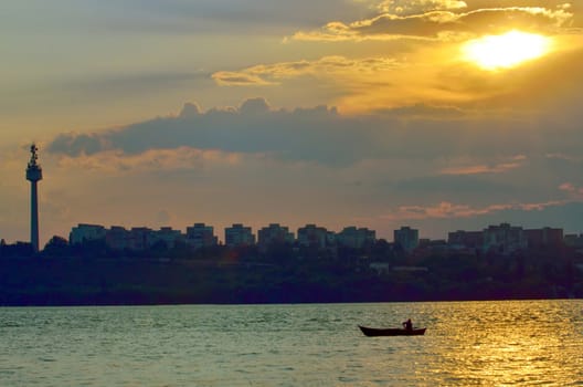 fishermen in boat at sunset on danube river