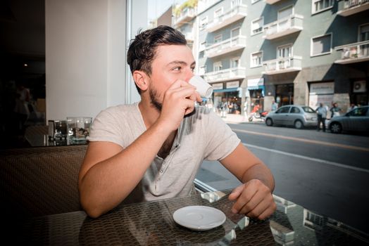young stylish man drinking coffee in a bar