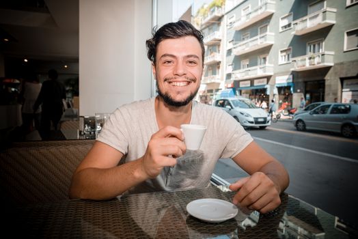 young stylish man drinking coffee in a bar