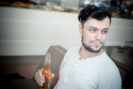young stylish man drinking beer in a bar