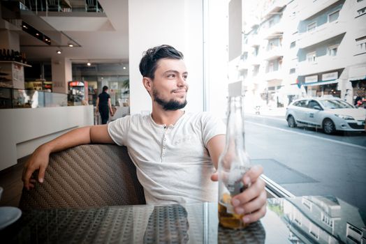 young stylish man drinking beer in a bar