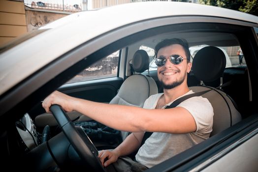 stylish man driving car in the city