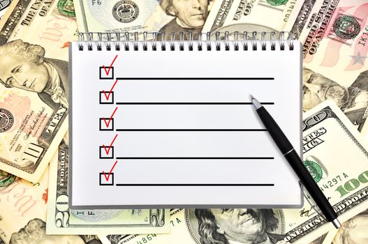 notebook with checklist on money background