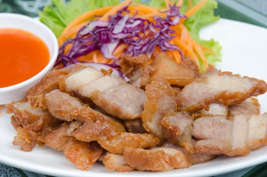 fried pork  served with fresh  vegetable and chili sauce on white plate