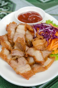 close up fried pork  served with fresh  vegetable and red sauce 