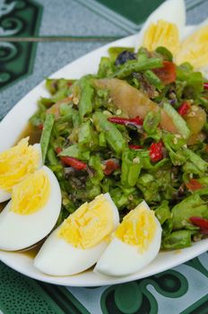 String bean spicy salad on plate served boiled egg