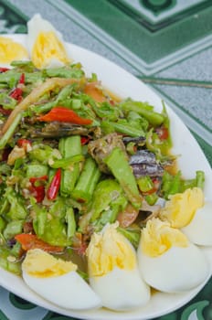 String bean spicy salad served with slice boiled egg on  white plate , spicy and sour