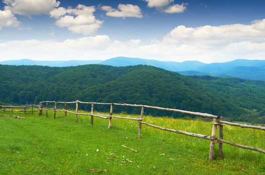 Wooden fence in a meadow in the mountains