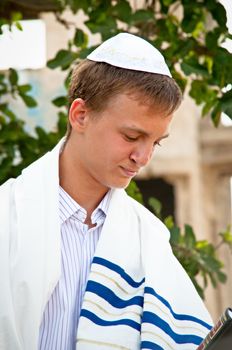 Religious Jewish teenager with a book in hand .