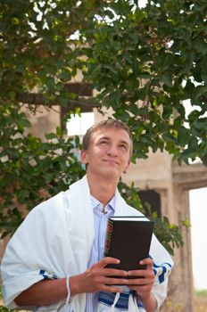 Religious Jewish teenager with a book in hand .