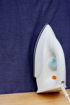 Electric iron  on blue cloth background