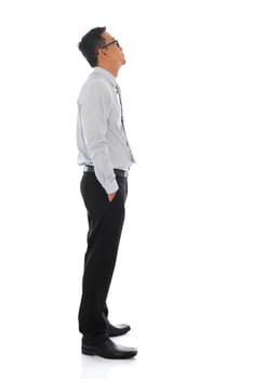 Full body young Asian businessman side view looking up. Standing isolated on white background
