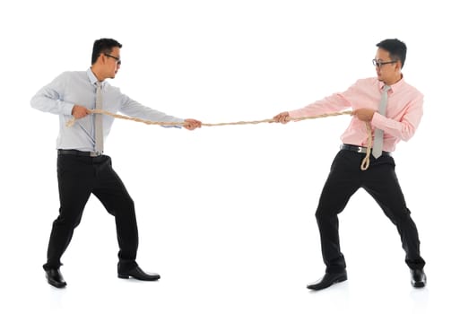 Full body two Asian businessmen pulling a rope, isolated on white background. Asian male model.