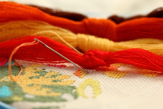 a tangle of colored threads for embroidery and needle