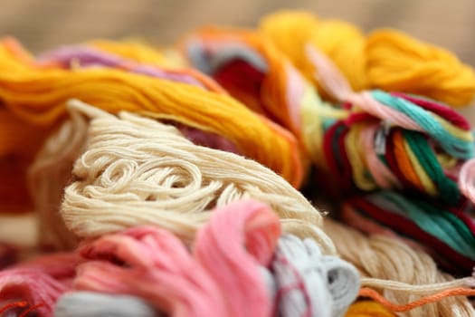 a tangle of colored threads for embroidery and needle