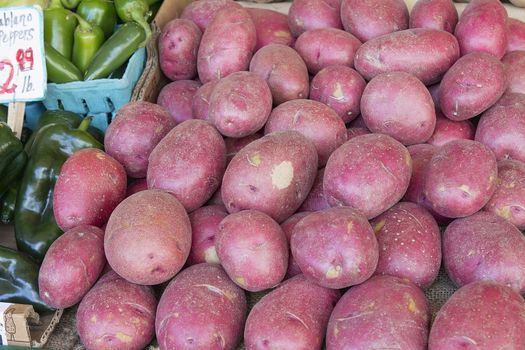 Red Skin Potatoes Display next to Chili Peppers at Farmers Market Fruits and Vegetables Stall