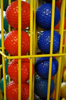 Red and Blue Golf Balls in Yellow Cage