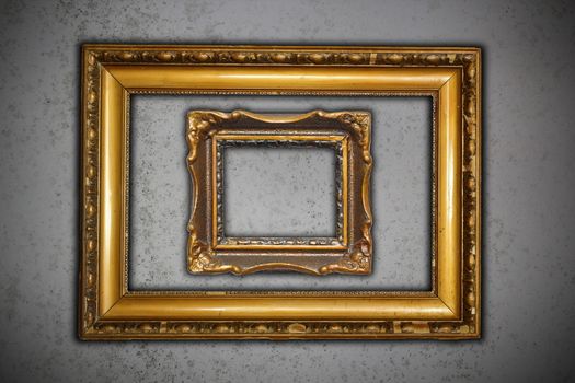 two ancient carved on wood frames for paintings on grungy cement wall