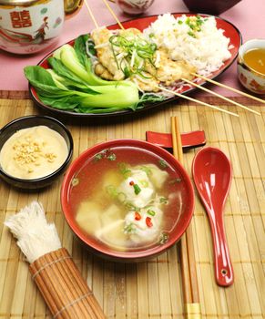 Delicious Chinese short soup with chicken skewers and vegetables. 