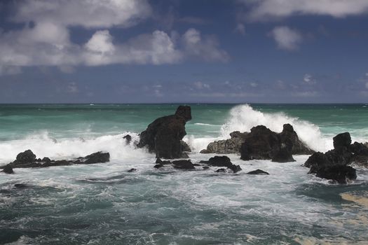 volcanic rock formation being pounded by wave