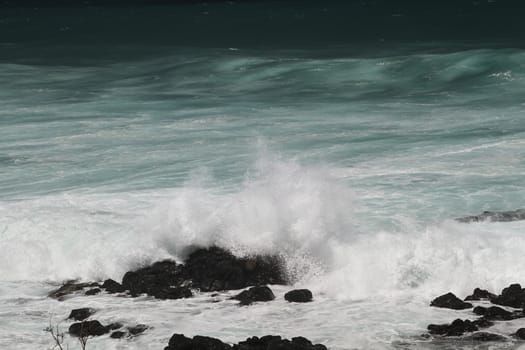 close-up of a wave crashing over rocks