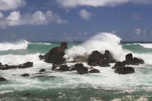 volcanic rock formation being pounded by wave