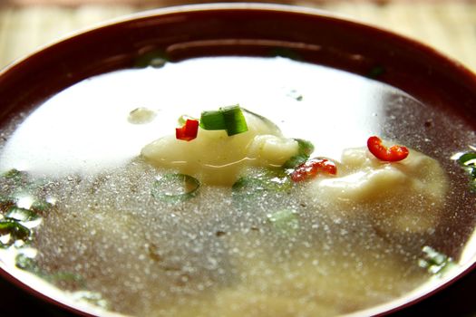 Delicious short soup made of Chinese dumplings in chicken broth with shallots.