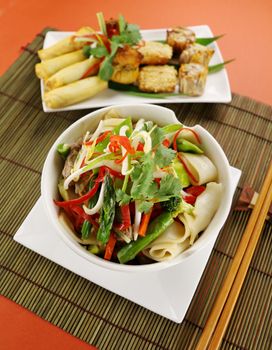 Freshly prepared beef noodle stirfry with dimsums ready to serve.