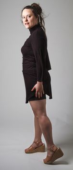 Woman wearing a black dress with wispy flowing hair, looking over her shoulder