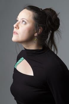 Woman wearing a black dress with wispy flowing hair looking up